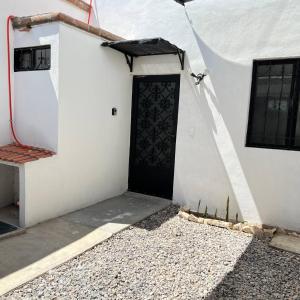 a white building with a black door on it at Casa en Tehuacán Se puede facturar in Cedro