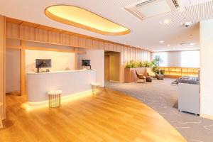 an office lobby with a reception desk and chairs at Richmond Hotel Miyazakiekimae in Miyazaki