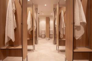 a walk in closet with wooden cabinets and towels at Little Drifter Cairns in Cairns +44 photos
