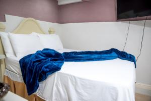 Una cama blanca con una manta azul. en Top Bay Apartments - All 5 Units, en Montego Bay