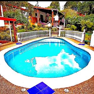 a swimming pool in the middle of a yard at Rincón del Colibrí in La Vega