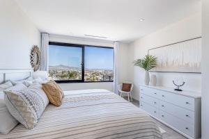 una camera da letto con un letto grande con una grande finestra di Cabo Penthouse Rooftop Pool Walk to Marina a Cabo San Lucas