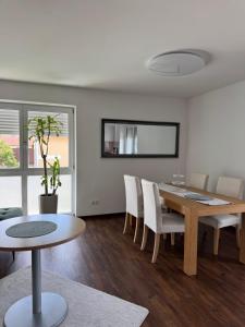 a living room with a dining room table and chairs at Moderne Wohnung 100 m2 mit Büro und Terrasse in Mühldorf +14 photos