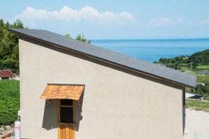 Noda藍宿ル1185的一座白色的小建筑,设有窗户和屋顶