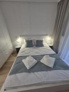 ein großes weißes Bett mit zwei Kissen darauf in der Unterkunft Apartament Alicja Plażowa Park in Międzywodzie