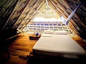 a room with a bed in a straw hut at Canto de Caracola in Rincón