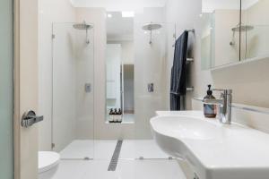 a white bathroom with a sink and a shower at Portside by Property Mums in Melbourne +11 photos