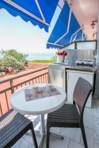 a white table and chairs on a balcony with a kitchen at Astris Beach in Astris