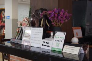un tavolo con libri e fiori sopra di CHORLADA LANNA HOTEL a Chiang Mai