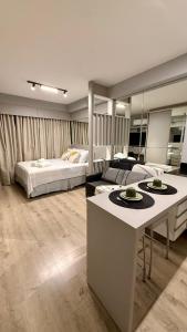 a large bedroom with a bed and a table in it at Studio Lifespace moderno no Batel in Curitiba