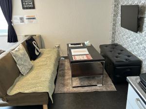 a living room with a couch and a table at アンブローシア平岸 in Toyohira