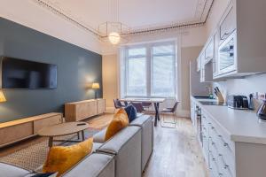 un soggiorno con un divano, un tavolo e una cucina di 3BR Gem West End Walk to Glasgow Uni Parking a Glasgow