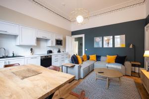 una cucina e un soggiorno con un divano e un tavolo di 3BR Gem West End Walk to Glasgow Uni Parking a Glasgow 1 altra foto