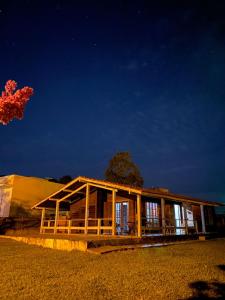 a building with a tree in front of it at night at QUARTO Outono em Casa de Madeira no Alto da Serra - PetFriendly in São Roque