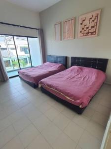 two beds in a room with a large window at 74 pangkorocean villa88 in Kampong Sungai Udang