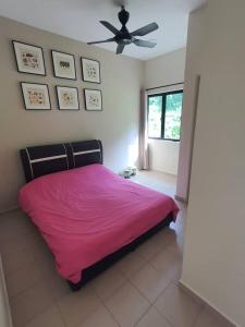 a bedroom with a pink bed and a ceiling fan at 74 pangkorocean villa88 in Kampong Sungai Udang