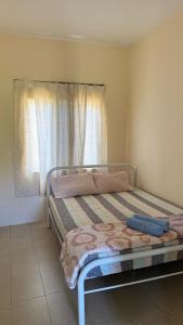 a bedroom with a bed and a window with curtains at MP Homestay Kota Marudu in Kampong Sorosob +3 photos