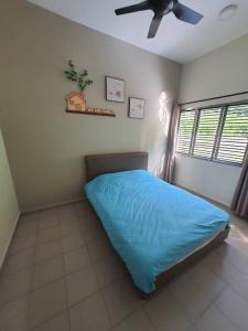 a bedroom with a blue bed and a ceiling fan at 74 pangkorocean villa88 in Kampong Sungai Udang +2 photos