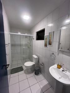 ein weißes Badezimmer mit Toilette und Waschbecken in der Unterkunft Ap 700m Praia Enseada-TV Smart, Garagem-Elevador in Guarujá