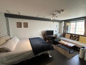 a bedroom with a large bed and a couch at アンブローシア平岸 in Toyohira +42 photos