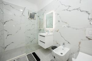 a white bathroom with a sink and a toilet at IZZY Apartments in Tirana +26 photos