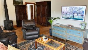a living room with a couch chairs and a dresser at The Willow Bank Guest House in Wakefield
