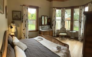 a bedroom with a bed in a room with windows at The Willow Bank Guest House in Wakefield