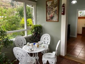 a white table and chairs in a room with a window at The Willow Bank Guest House in Wakefield