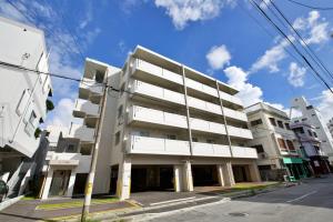 a large white building on a city street at Li Kotohogi 401 in Naha