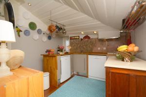 リスボンにあるCasa do Casteloのキッチン(白いキャビネット、青いラグ付)