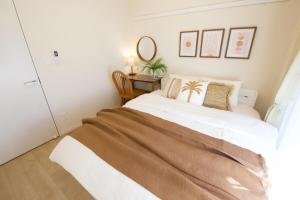 a bedroom with a bed and a table with a mirror at Li Kotohogi 401 in Naha