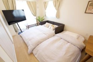 two beds sitting next to each other in a room at Li Kotohogi 401 in Naha