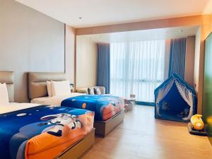 Una habitación de hotel con dos camas y una tienda de juegos. en Guangzhou Meihua Hotel, en Huadu