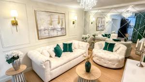 a living room with two white couches and green pillows at casona azul cusco in Cusco