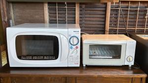 a microwave and a toaster oven sitting on a table at nano inn in Kanagawa