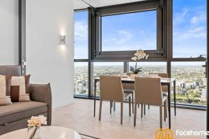 a dining room with a table and chairs and a large window at QW Luxury River City Views in Brisbane +44 photos