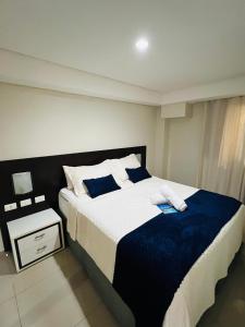 a bedroom with a large bed with blue and white sheets at Marinas Praia Flat 005 in João Pessoa +37 photos