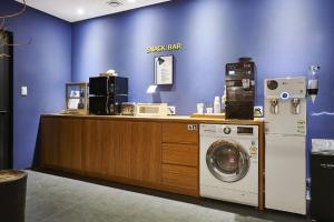 Una tienda con una lavadora y una pared azul. en Daejeon Yuseong Just Sleep Yuseong Hot Springs Branch, en Daejeon