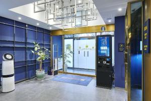Una habitación grande con una pared azul con una máquina expendedora. en Daejeon Yuseong Just Sleep Yuseong Hot Springs Branch, en Daejeon