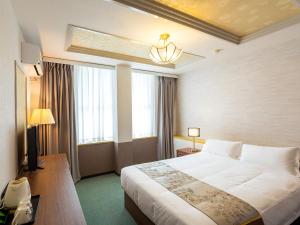um quarto de hotel com uma cama grande e janelas em ホテルオアシスガーデン em Obita