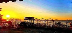 a view of a beach with the sunset in the background at Ganghwado Katana Pension in Incheon
