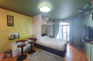 a bedroom with a bed and a table and a window at Ganghwado Katana Pension in Incheon