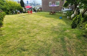 un patio con una mesa de picnic y un banco en Gangneung Anin Pension, en Gangneung 3 fotos más