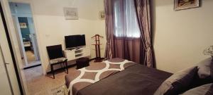 a bedroom with a bed and a television in it at La perle de Kouba lacroix in Alger