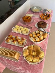 a table with various pastries and breads on it at Suitella in Cabo Frio +19 photos