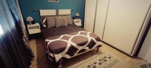 a bedroom with a bed with a brown and white comforter at La perle de Kouba lacroix in Alger