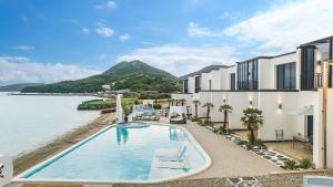 a resort swimming pool with a view of the water at Yeosu Cave Pool Villa in Yeosu