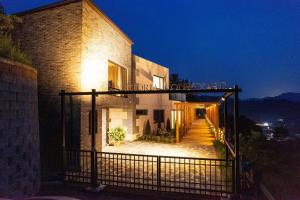 un edificio con un cancello di fronte ad esso di notte di Gapyeong V Courtyard Pension a Gapyeong Altre 3 foto