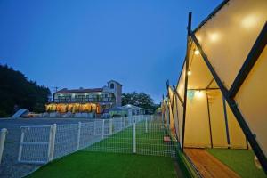 a fence in front of a building with lights at Anmyeondo Sea Garden Pension Bada-dong Pet Friendly in Taean +11 photos