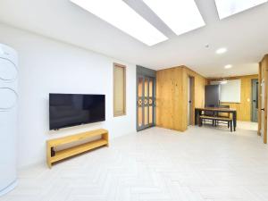 a living room with a flat screen tv on a wall at Gyeongju Art Hill Family Group Pet-Friendly Pension in Gyeongju
